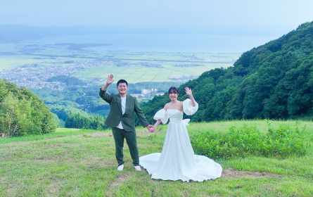 手をつなぎながらもう片方の手を振る男女